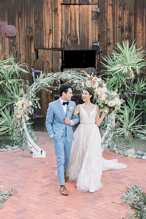  bridal gown with a keyhole back detailing  and the groom in a light blue suit with a blue velvet bow tie