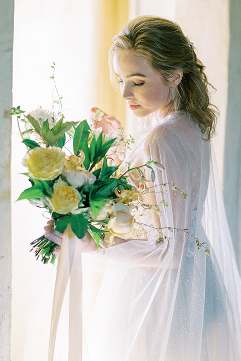  bride looking over her shoulder in a white flowing gown 