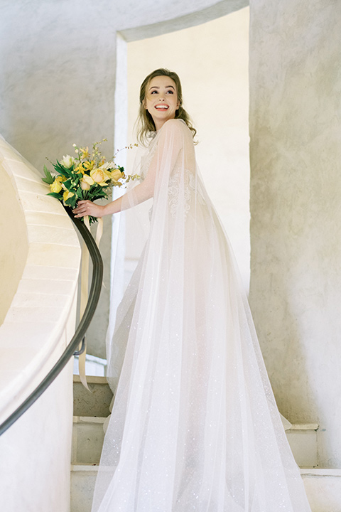  bride looking over her shoulder in a white flowing gown 