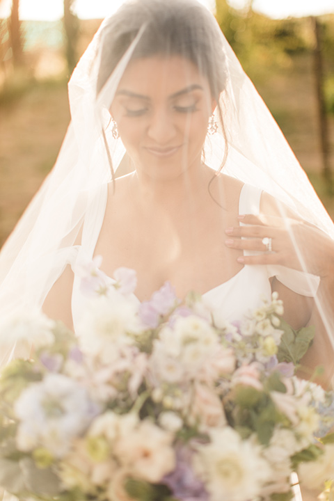  bride in a white flowing gown with off the shoulder detailing 