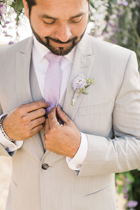  the groom in a light grey suit with a lilac lavender long tie