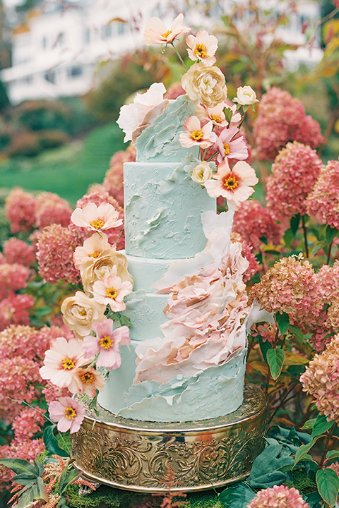  light blue cake with various pink colored flowers on it