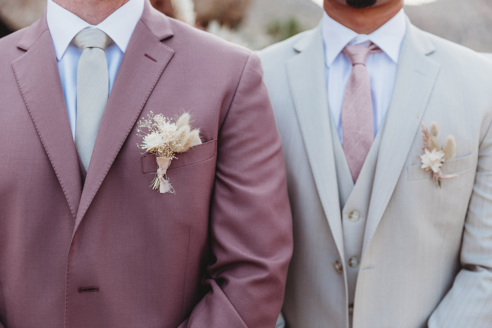  groom in a pink suit with long tie and the groomsman in a tan suit and pink tie