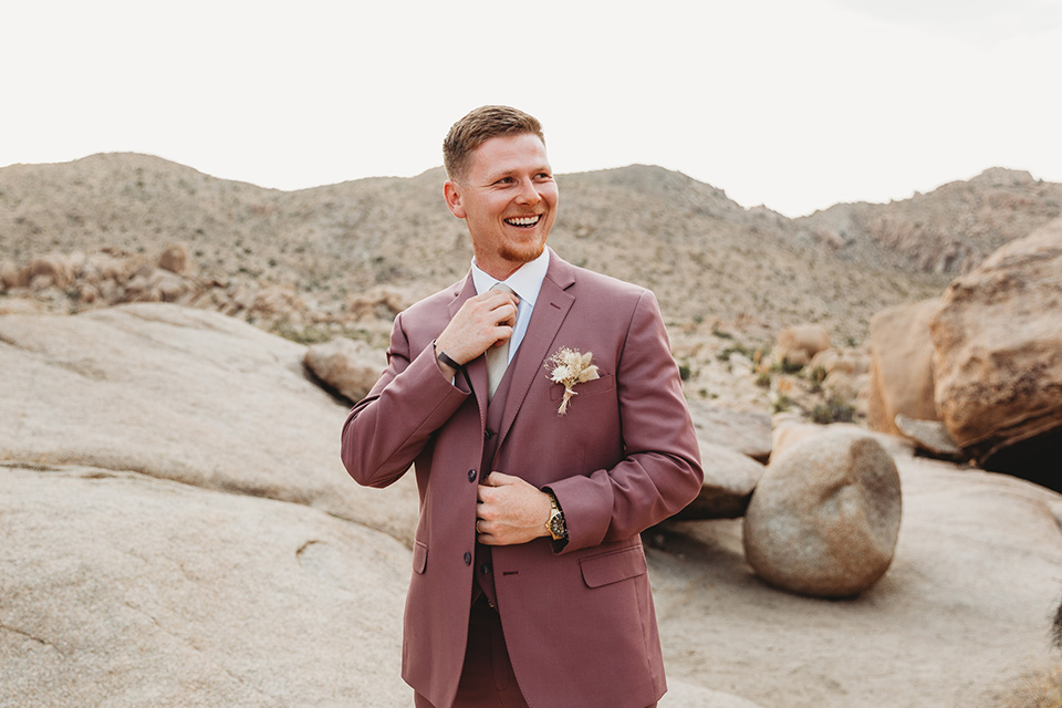  groom in a pink suit with long tie and the groomsman in a tan suit and pink tie