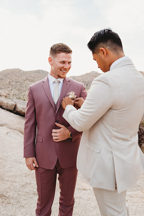  groom in a pink suit with long tie and the groomsman in a tan suit and pink tie 