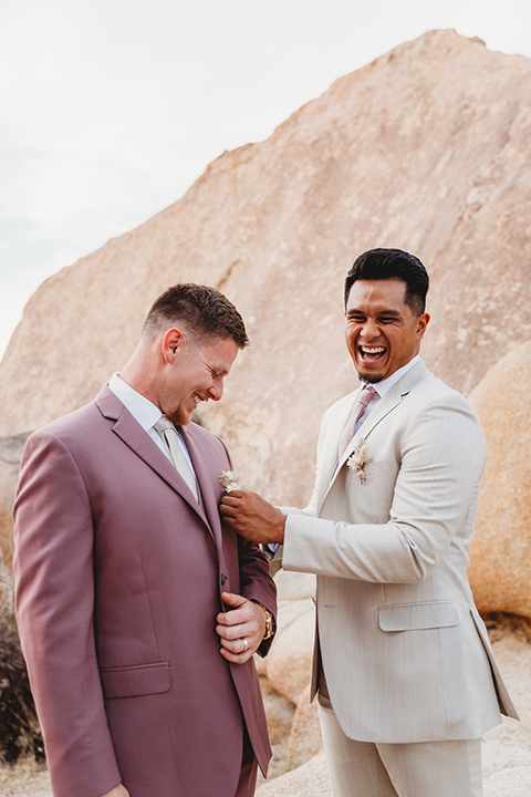  groom in a pink suit with long tie and the groomsman in a tan suit and pink tie 