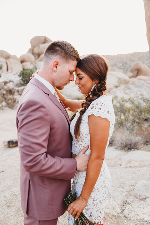  groom in a pink suit with long tie and the groomsman in a tan suit and pink tie 