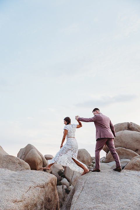  groom in a pink suit with long tie and the groomsman in a tan suit and pink tie 