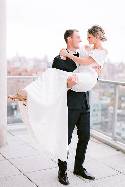  bride in a white gown with an off the shoulder detail and the groom in a blue shawl tuxedo