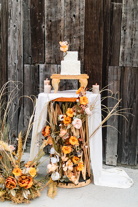  bride in a flowing bohemian gown with her hair in a loose braided bun and flowers 