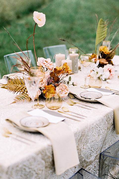  bride in a flowing bohemian gown with her hair in a loose braided bun and flowers and the groom in an asphalt grey suit 