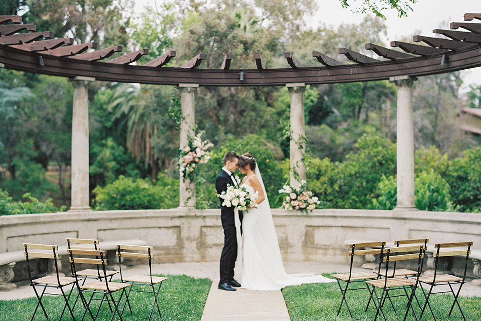  bride in a modern gown with a strapless neckline and the groom in a black tuxedo and bow tie 