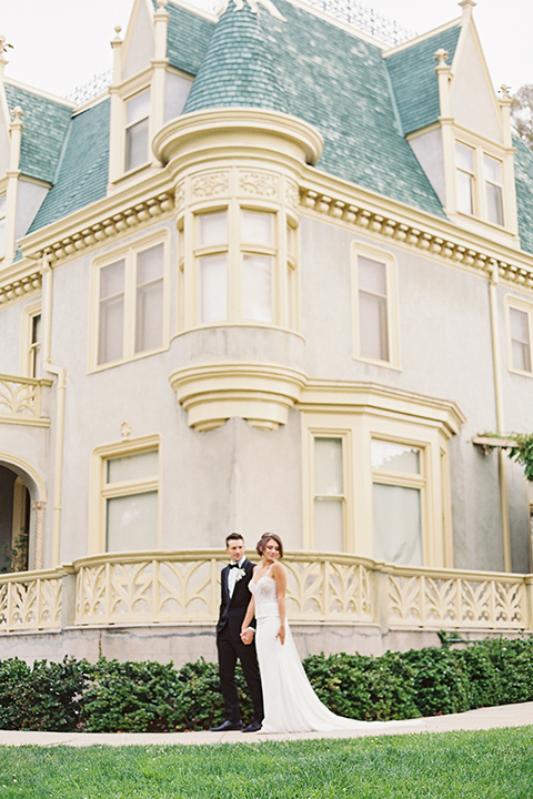  bride in a modern gown with a strapless neckline and the groom in a black tuxedo and bow tie 