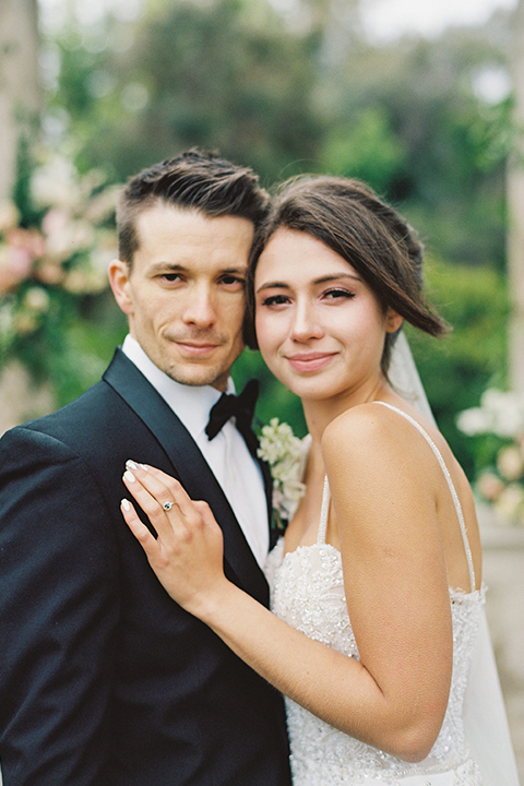  bride in a modern gown with a strapless neckline and the groom in a black tuxedo and bow tie 