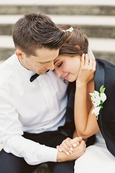 bride in a modern gown with a strapless neckline and the groom in a black tuxedo and bow tie 