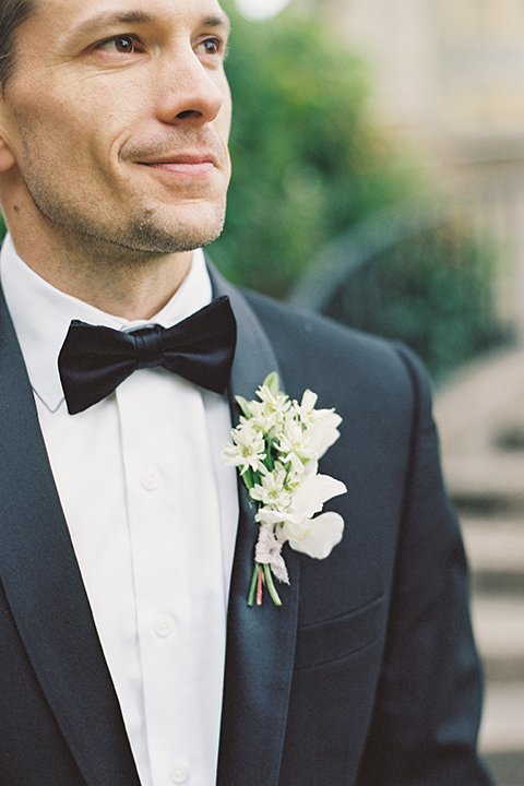  bride in a modern gown with a strapless neckline and the groom in a black tuxedo and bow tie 