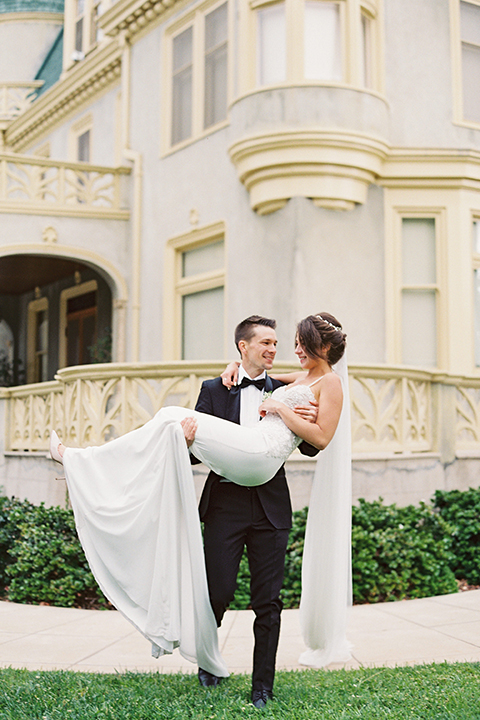  bride in a modern gown with a strapless neckline and the groom in a black tuxedo and bow tie 