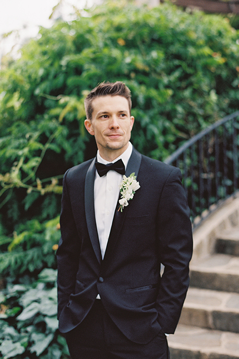  bride in a modern gown with a strapless neckline and the groom in a black tuxedo and bow tie 