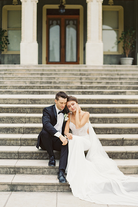  bride in a modern gown with a strapless neckline and the groom in a black tuxedo and bow tie 