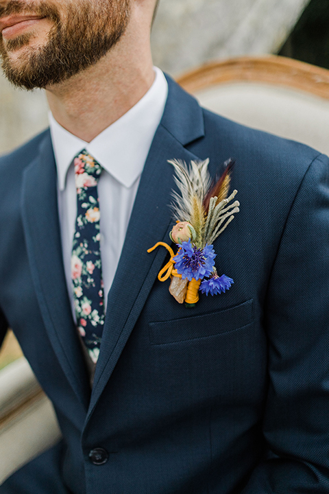  bride in an ivory and champagne gown with sleeves and the groom in a blue suit with a blue floral neck tie 