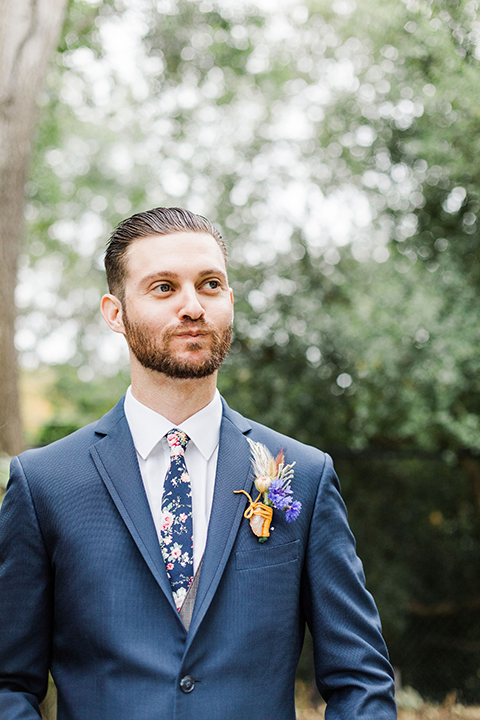  bride in an ivory and champagne gown with sleeves and the groom in a blue suit with a blue floral neck tie 