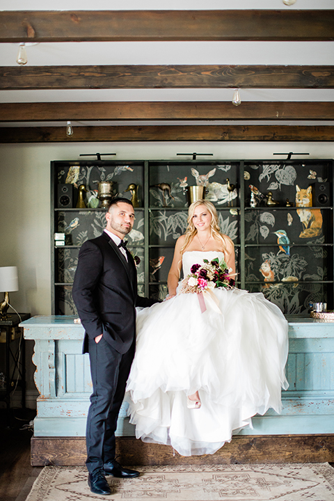  bride in a strapless white ball gown and the groom in a black tuxedo with black bowtie 