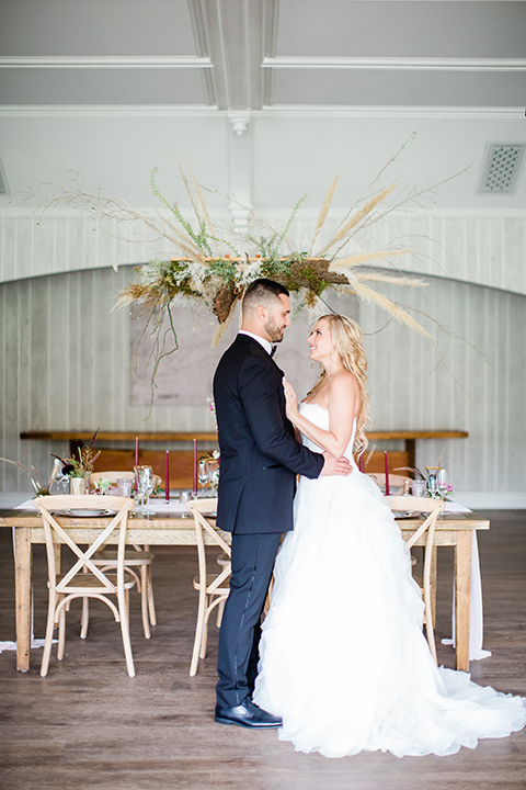  bride in a strapless white ball gown and the groom in a black tuxedo with black bowtie 