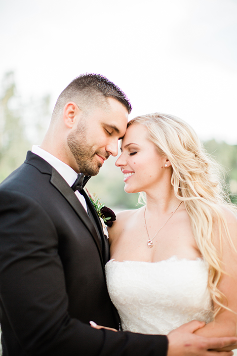  bride in a strapless white ball gown and the groom in a black tuxedo with black bowtie 