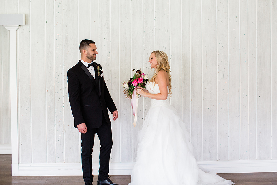  bride in a strapless white ball gown and the groom in a black tuxedo with black bowtie 