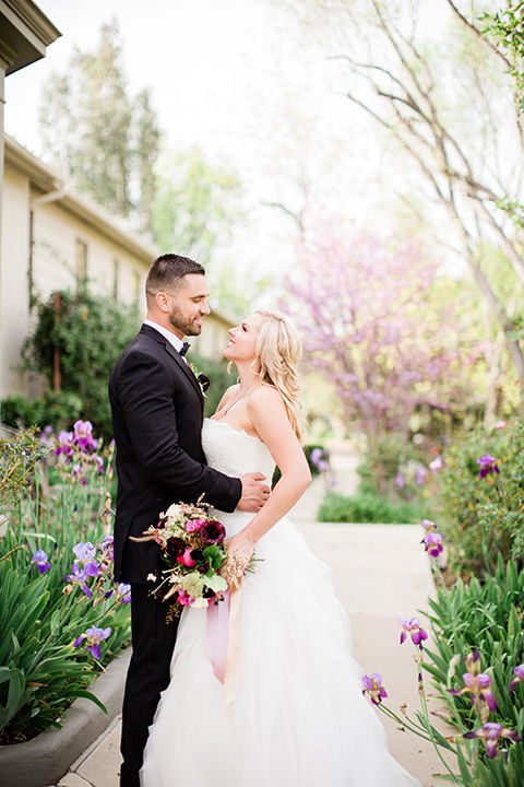  bride in a strapless white ball gown and the groom in a black tuxedo with black bowtie 