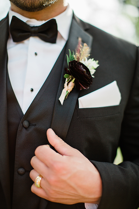  bride in a strapless white ball gown and the groom in a black tuxedo with black bowtie 