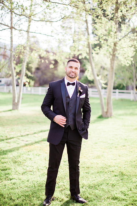  bride in a strapless white ball gown and the groom in a black tuxedo with black bowtie 