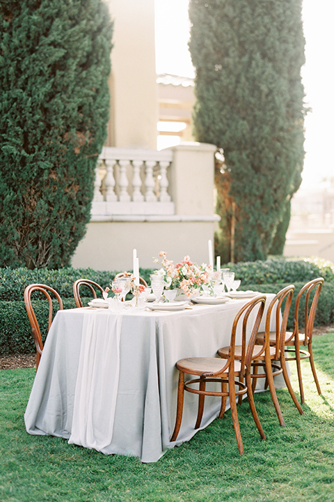  bride in a formfitting white lace gown with an off the shoulder detail  and the groom in a navy shawl lapel tuxedo