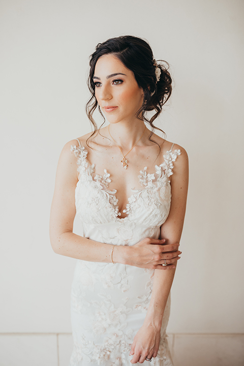  bride in a flowing lace gown and the groom in a rose pink suit 