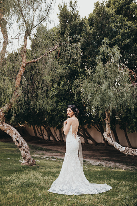  bride in a flowing lace gown and the groom in a rose pink suit