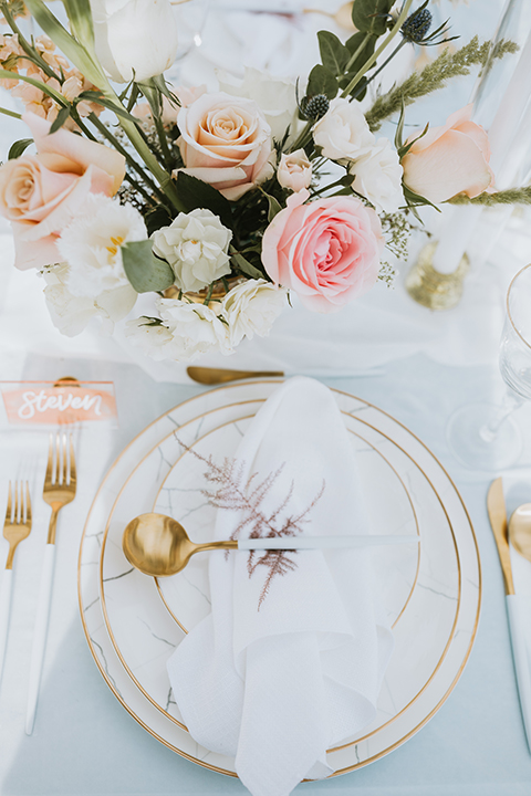  bride in a flowing lace gown and the groom in a rose pink suit 