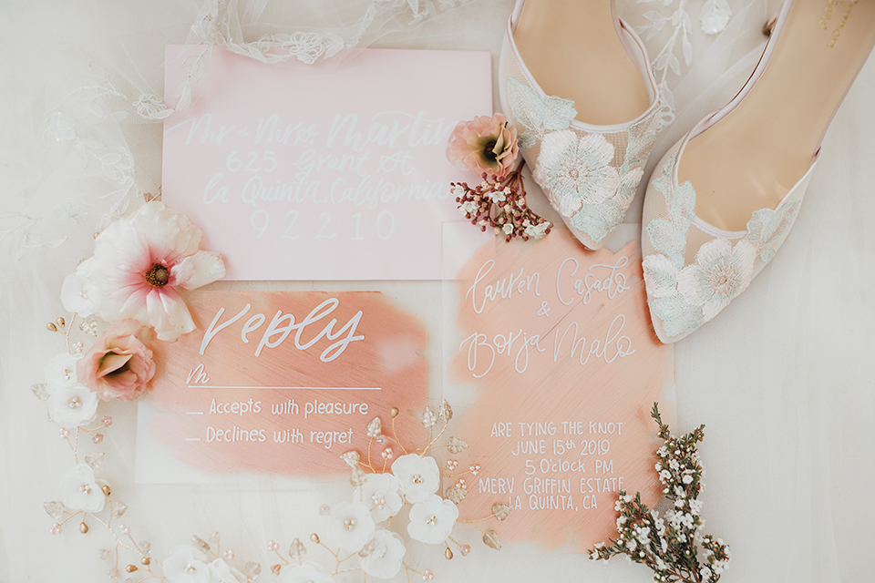  bride in a flowing lace gown and the groom in a rose pink suit 