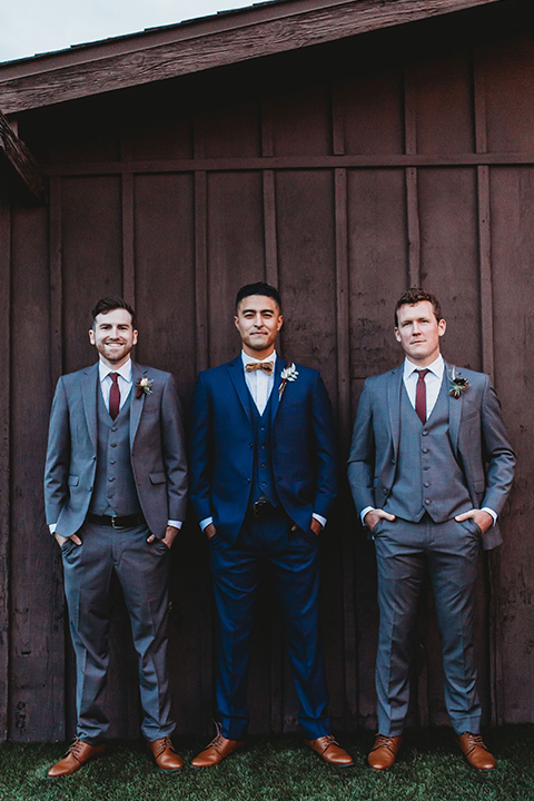  groom and groomsmen in different shades of blue and grey suits