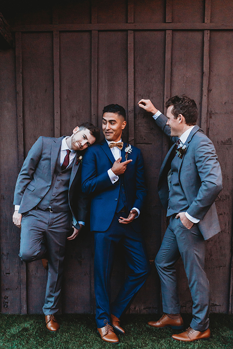  groom and groomsmen in different shades of blue and grey suits 