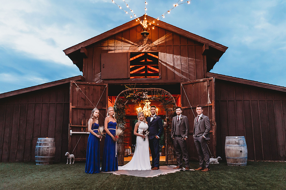  bride in a boho gown with her hair in a long french braid and he groom in a cobalt blue suit 