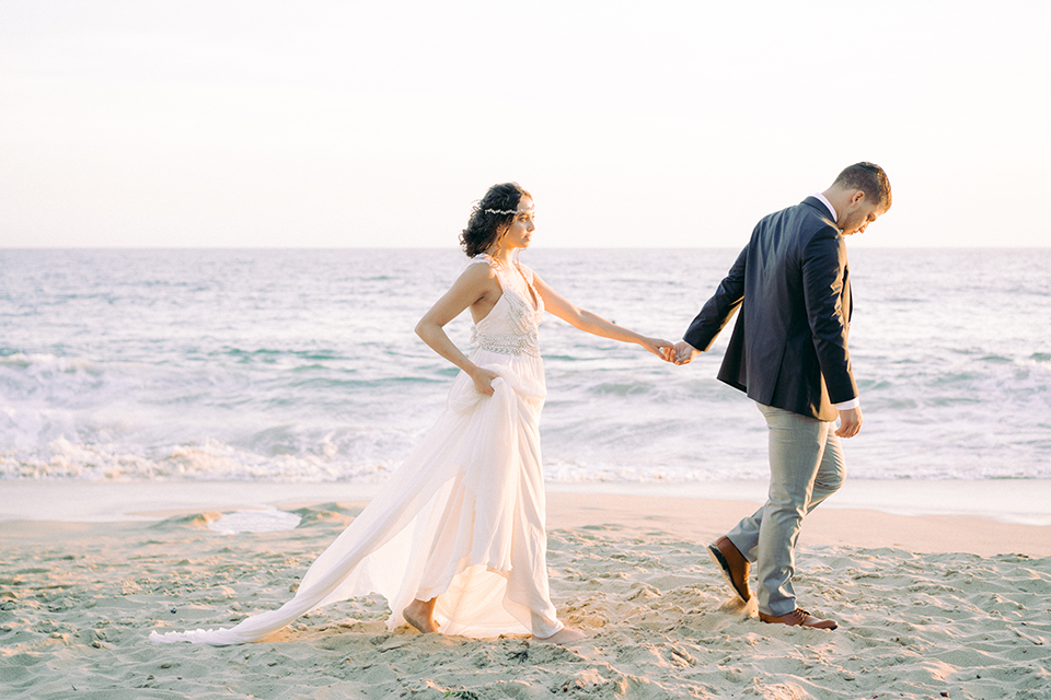  bride in  flowing gown with embellishments and the groom in a dark grey coat with light grey pants 