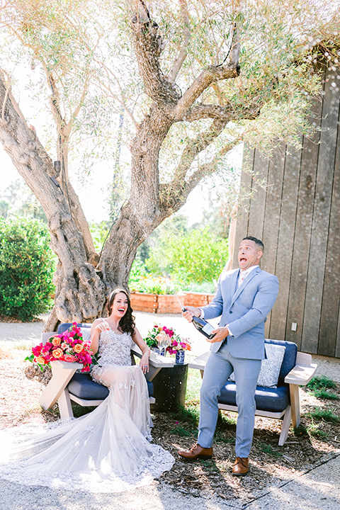  the bride in a lace gown and jean jacket and the groom in a light blue suit with a white floral long tie 