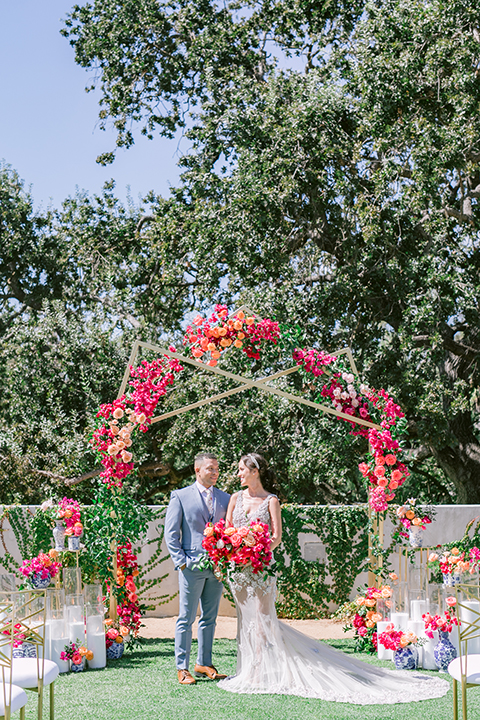  the bride in a lace gown and jean jacket and the groom in a light blue suit with a white floral long tie 