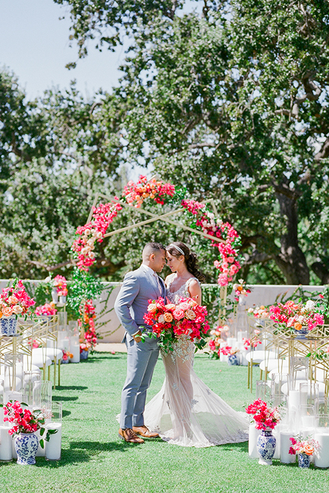  the bride in a lace gown and jean jacket and the groom in a light blue suit with a white floral long tie 