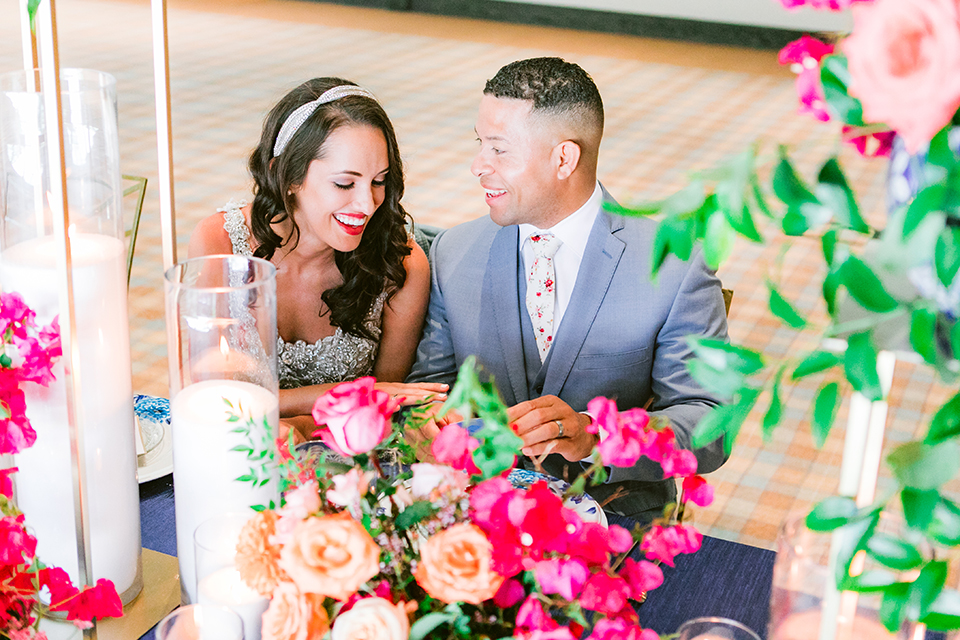  the bride in a lace gown and jean jacket and the groom in a light blue suit with a white floral long tie 