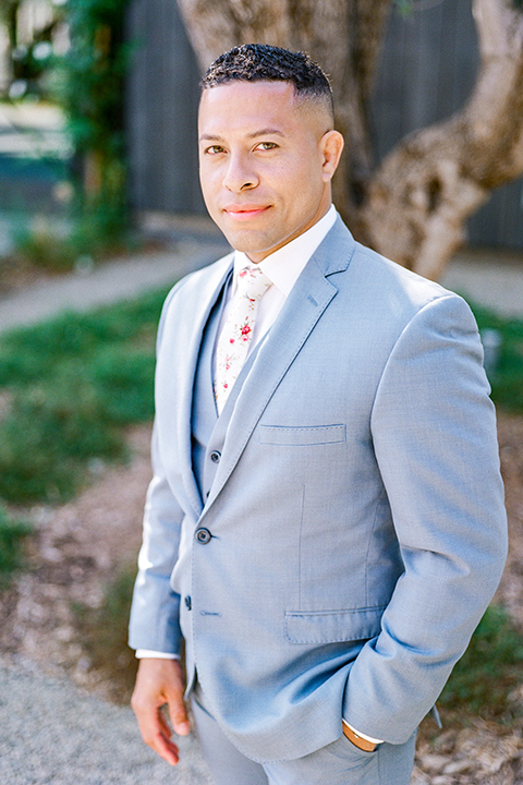  the bride in a lace gown and jean jacket and the groom in a light blue suit with a white floral long tie 