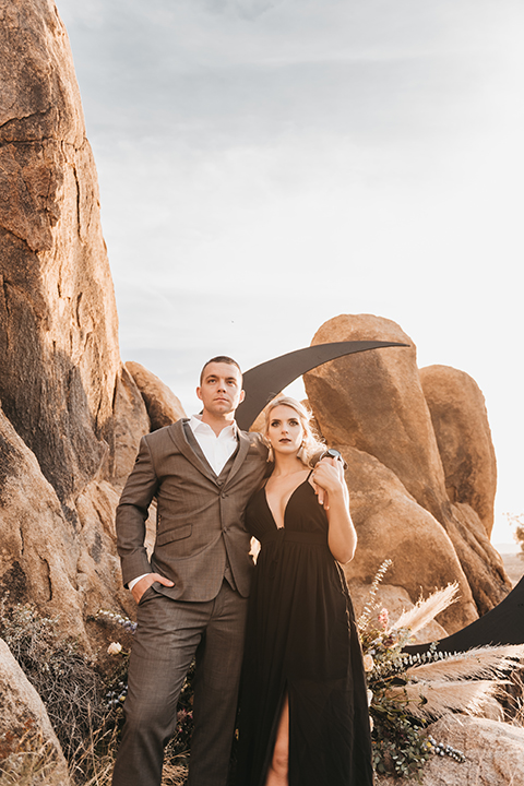  bride in a black gown and the groom in a café brown suit 