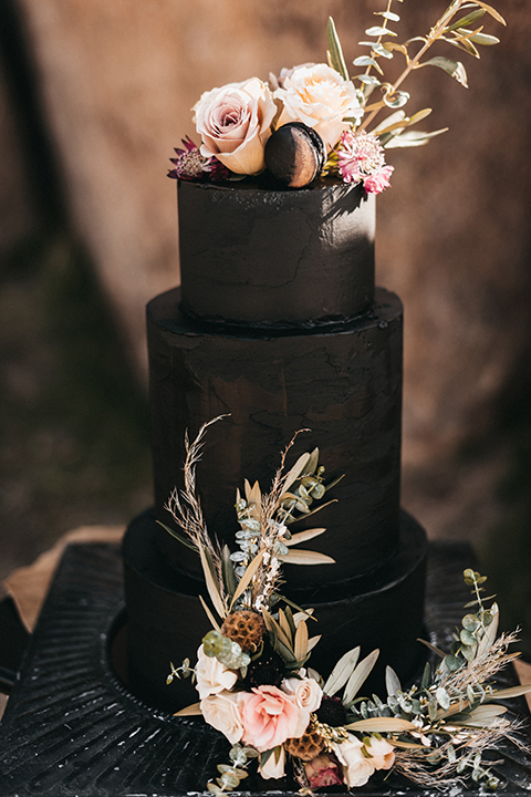  bride in a black gown and the groom in a café brown suit