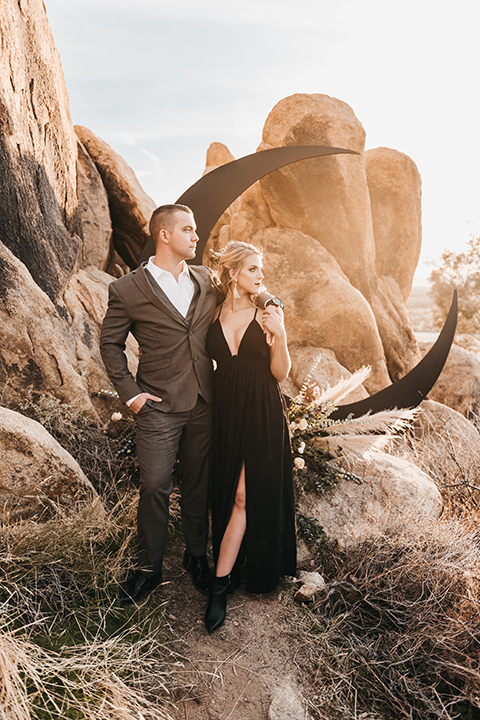  bride in a black gown and the groom in a café brown suit 