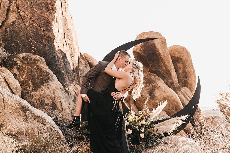  bride in a black gown and the groom in a café brown suit 